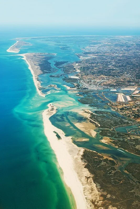 Aerial view of long sandy barrier islands and turquoise lagoons along the Ria Formosa coast