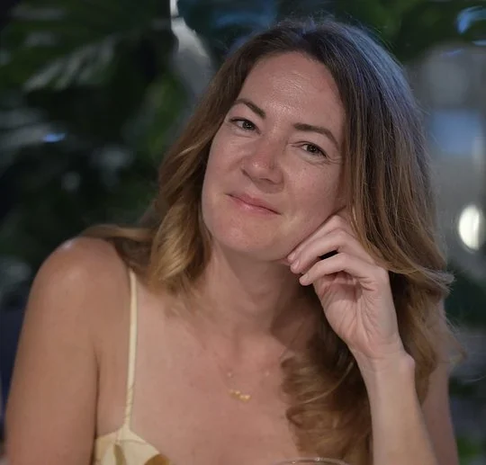 Amy Heinemann, retreat host, smiling with her chin resting on her hand