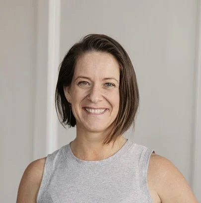 Tiffany Ingersoll smiling in a gray tank top against a light wall