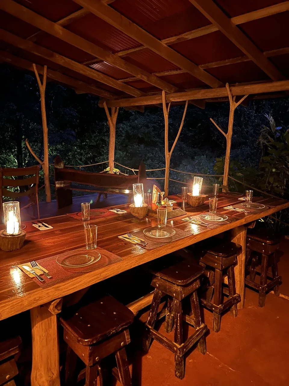 Candlelit outdoor dinner table set for guests at the Costa Rica retreat lodge