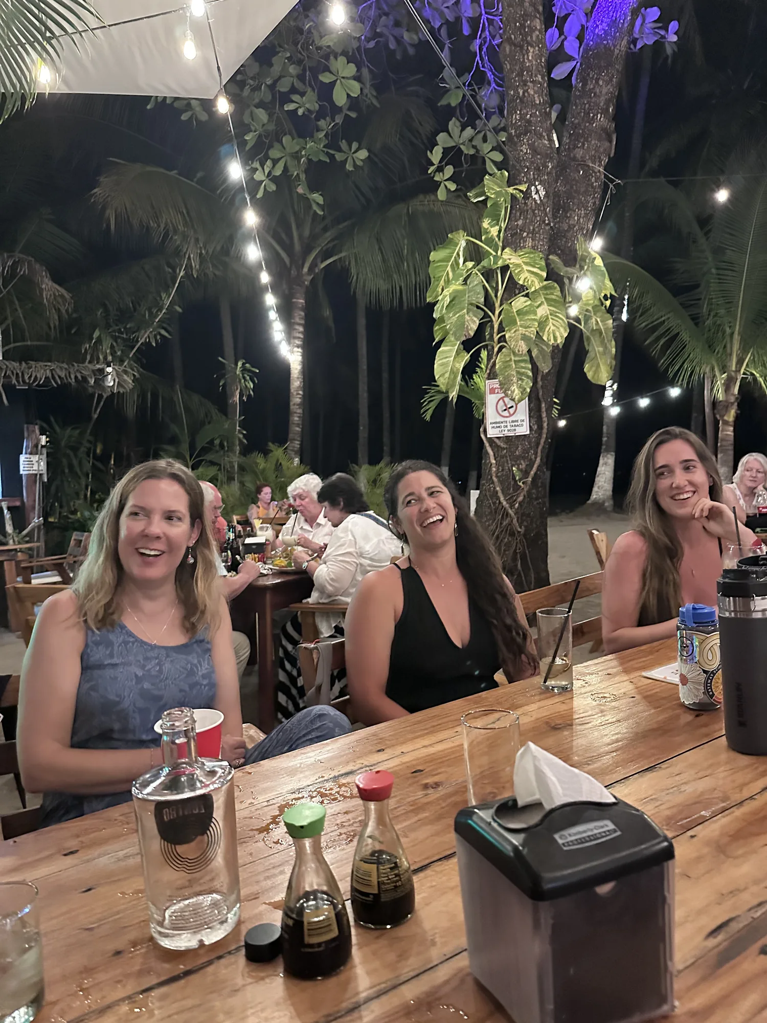 Away Retreats guests laughing together at a group dinner table at night