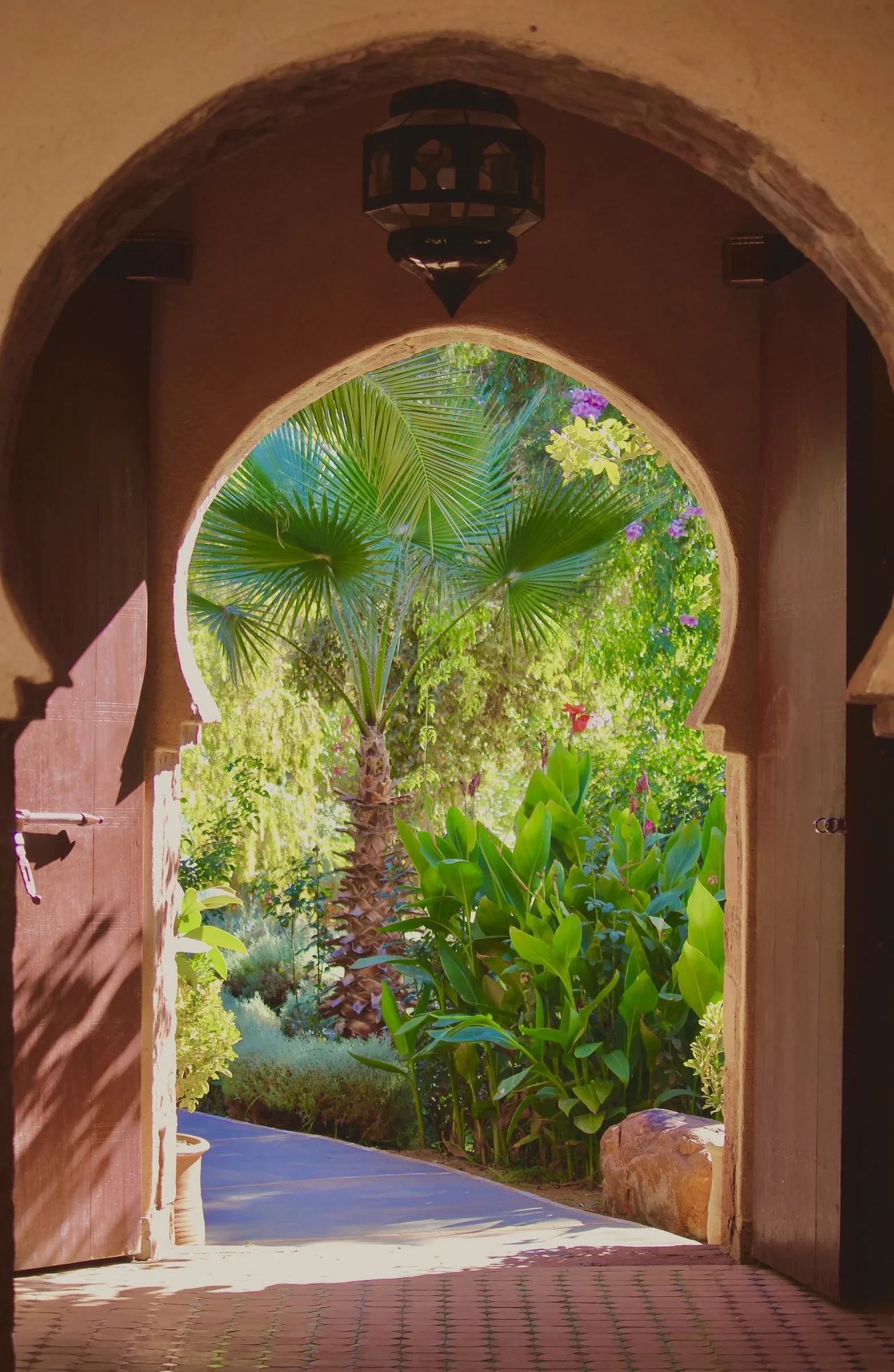 One of our reading retreats in Morocco: a keyhole archway opening onto a palm garden in the Ourika Valley