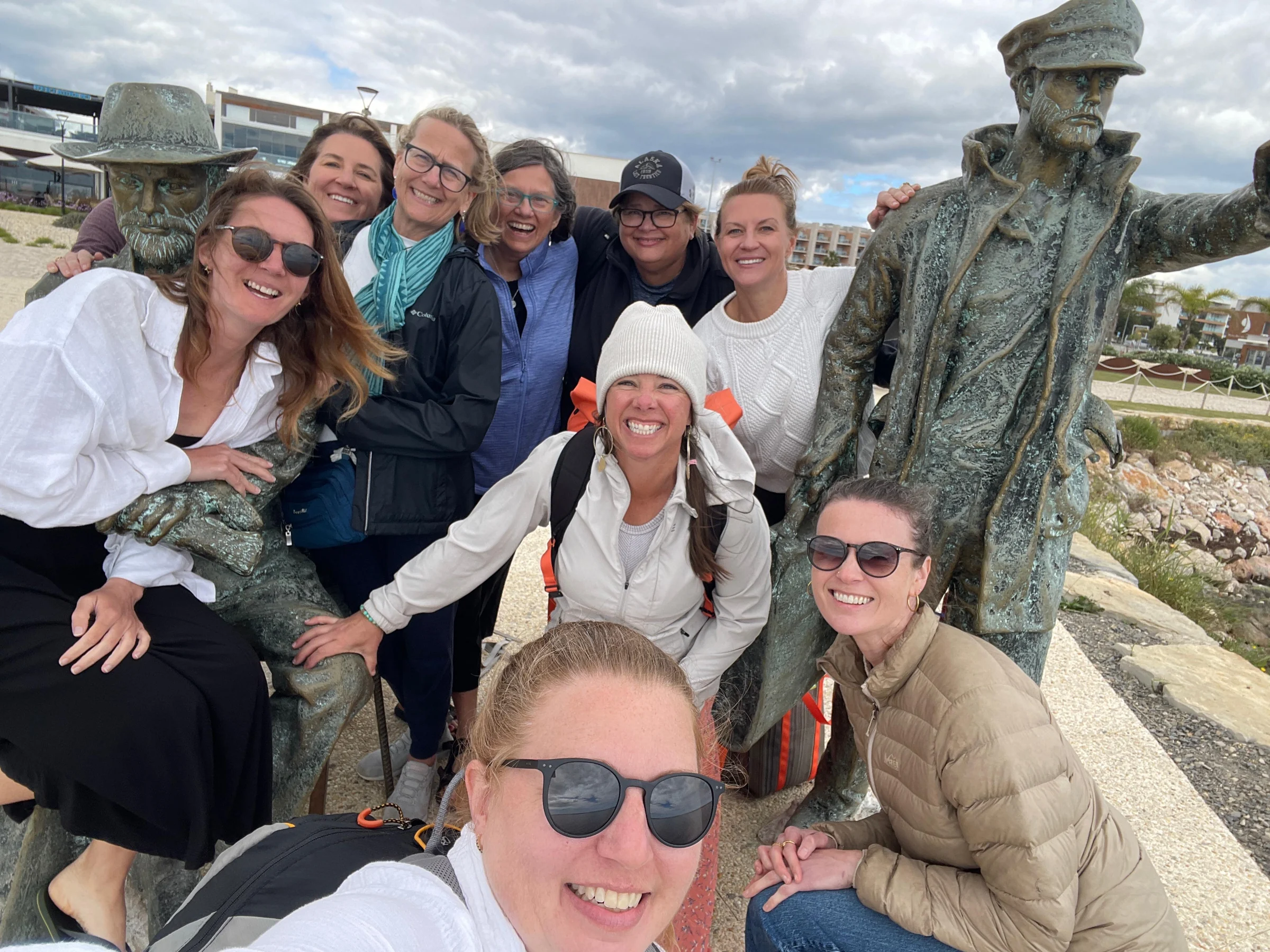 Away Retreats guests posing with waterfront statues in Portugal